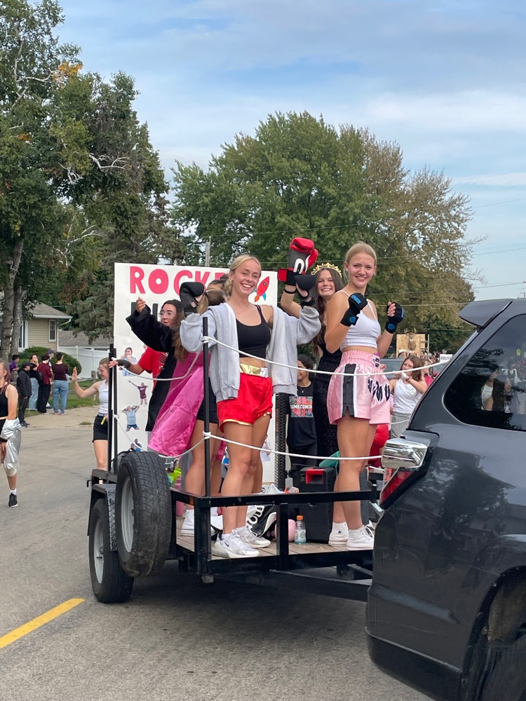 Girls pose on the back of a boxing themed float