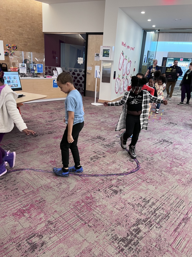 Students balance on a taped line on the floor.