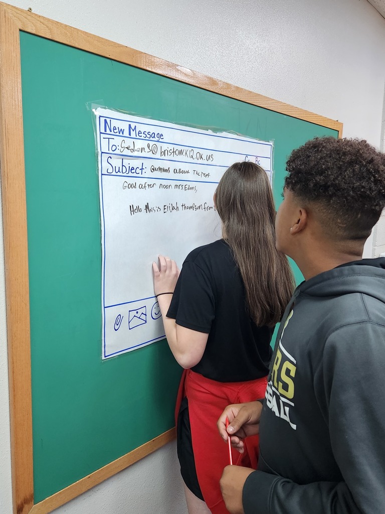 Students writing mock professional emails in groups.