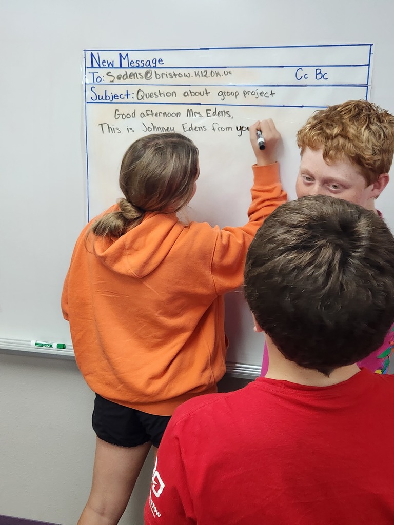 Students writing mock professional emails in groups.