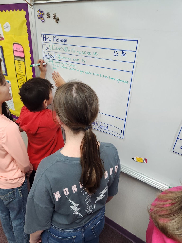 Students writing mock professional emails in groups.