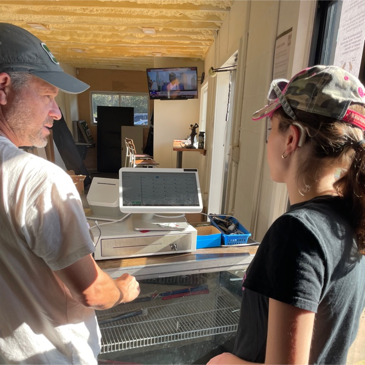 One of our students is learning how to use the register system at The Acres.