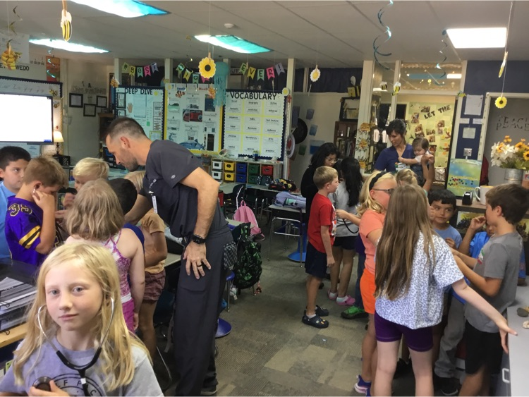 Dr.Miller showing the students how to use a stethoscope .