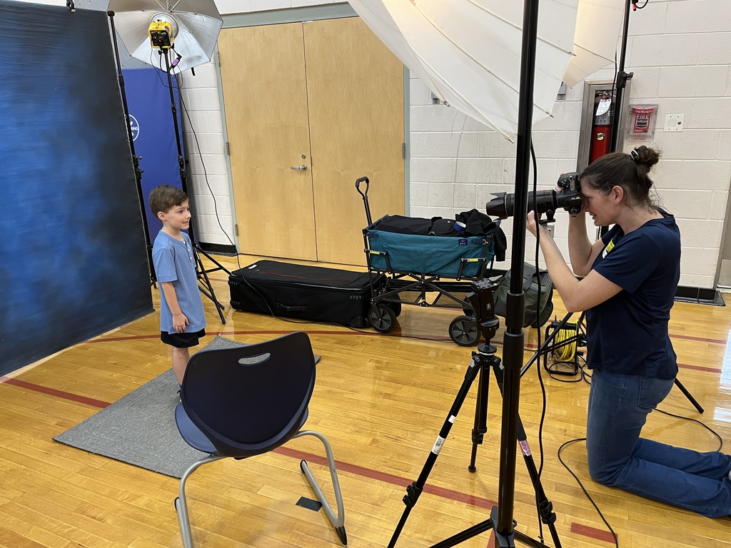 A photographer takes a photo of a child for Picture Day.