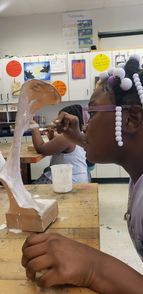 One student stares intently at her sculpture from a distance of 2 inches.