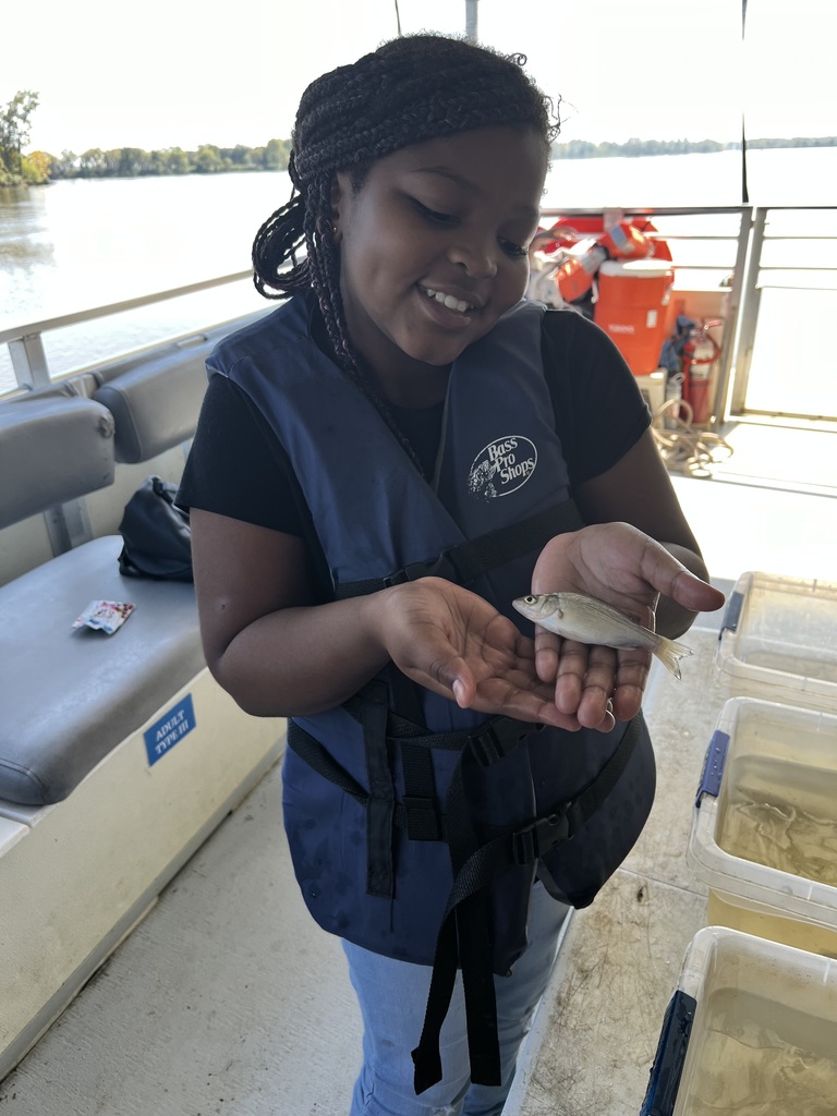 4th grade student holds a fish.