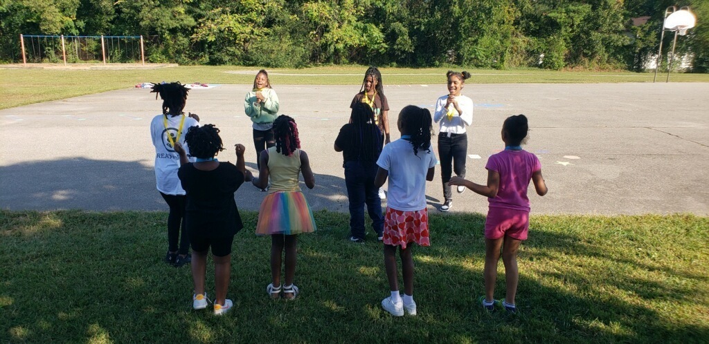 Older students and younger students cheer together.