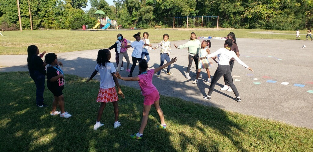 Older students lead younger students in an impromptu cheer practice.