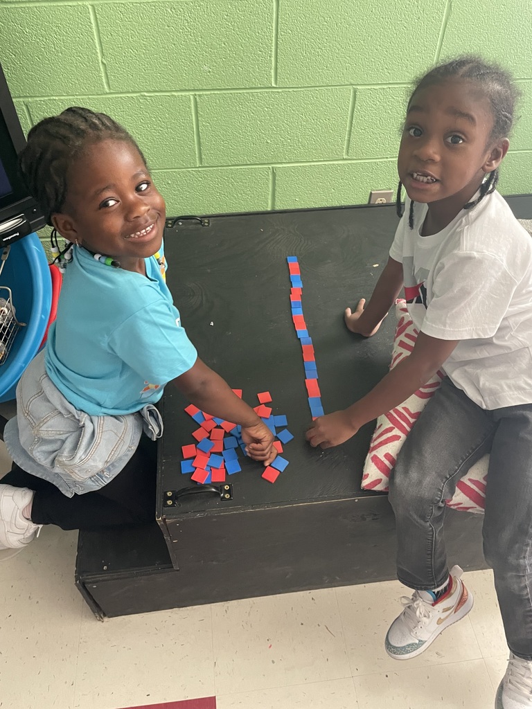 Two kindergarten students work with blocks to make a red blue pattern.