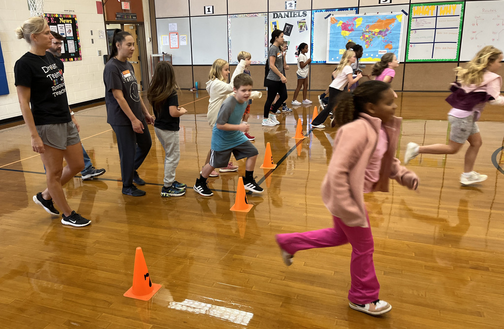 Children participate in PE class in a gym