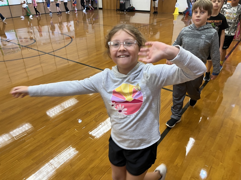 Children participate in PE class in a gym