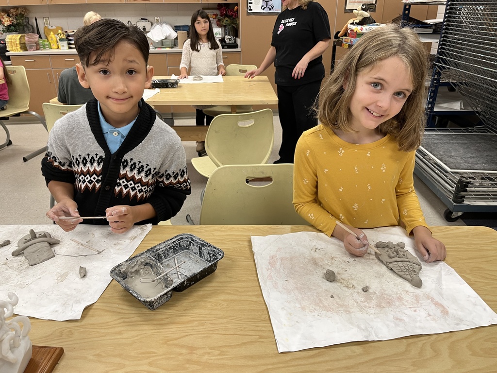 Two children build clay snowmen.