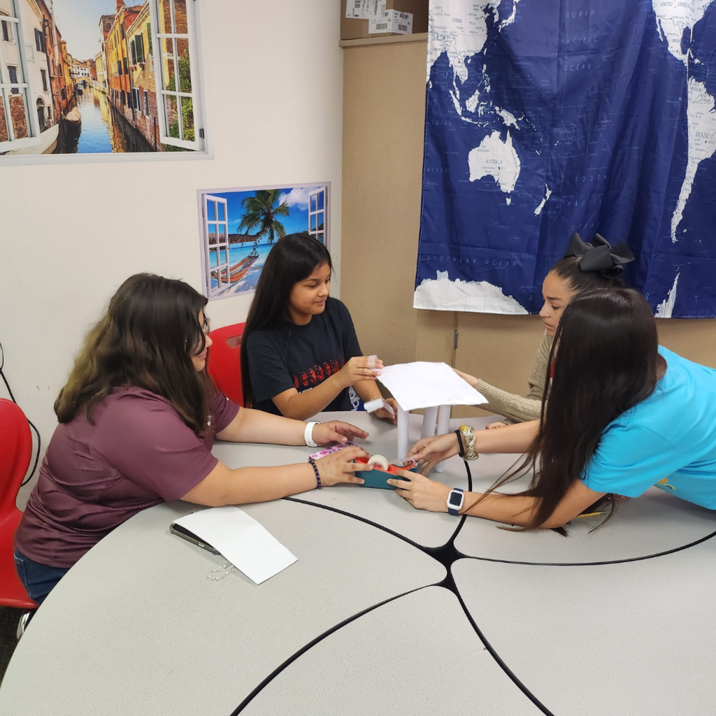 students at table creating their chair from paper