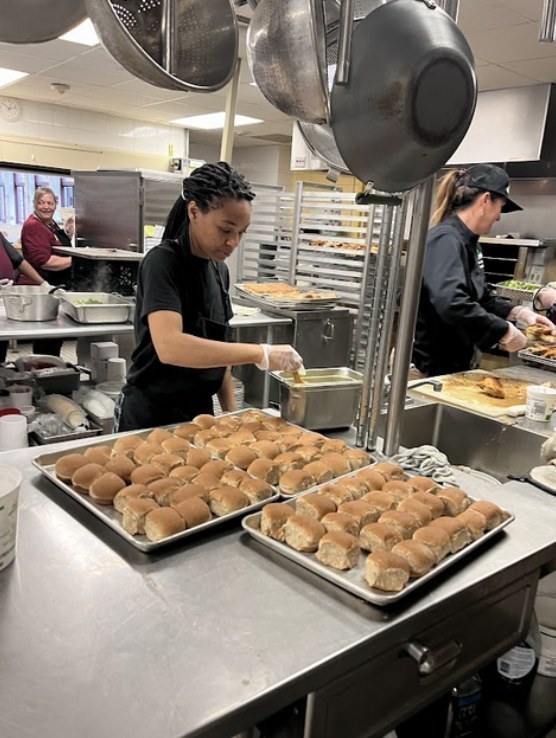 worker prepares school lunch