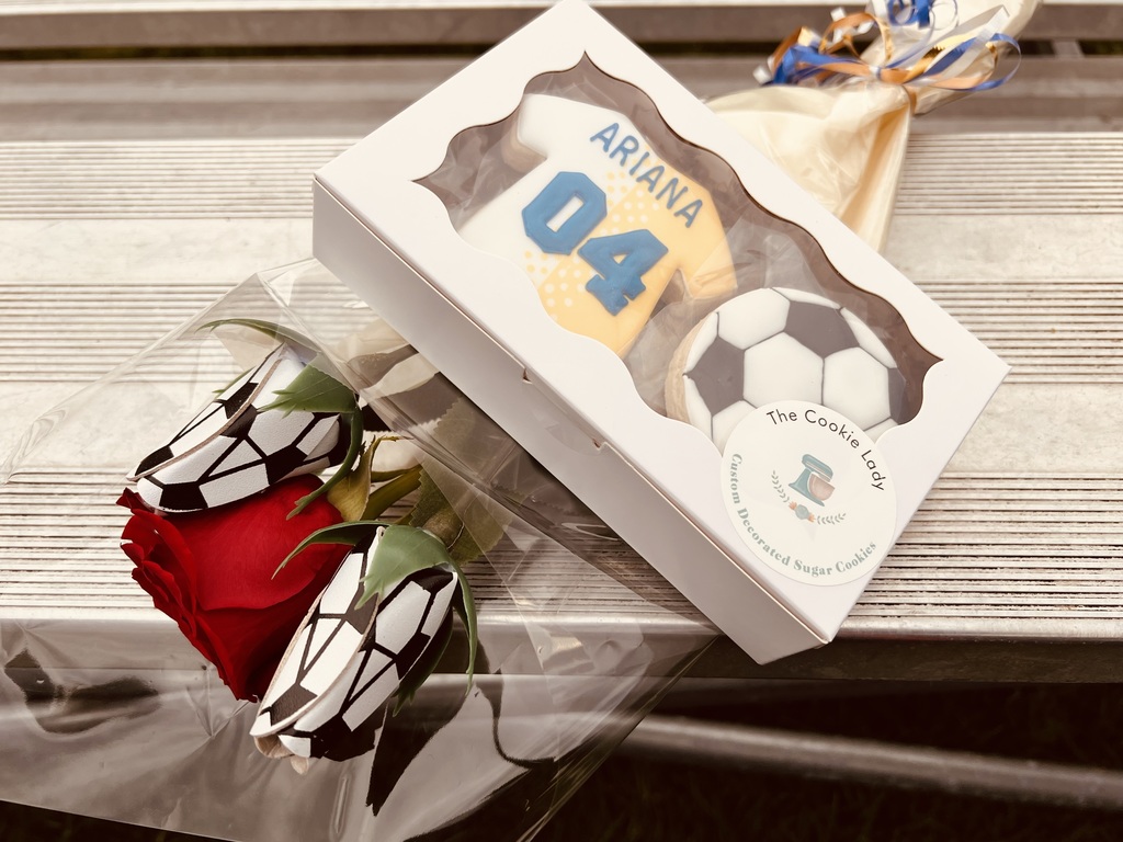 A rose and two hand decorated cookies that were handed out at the game today