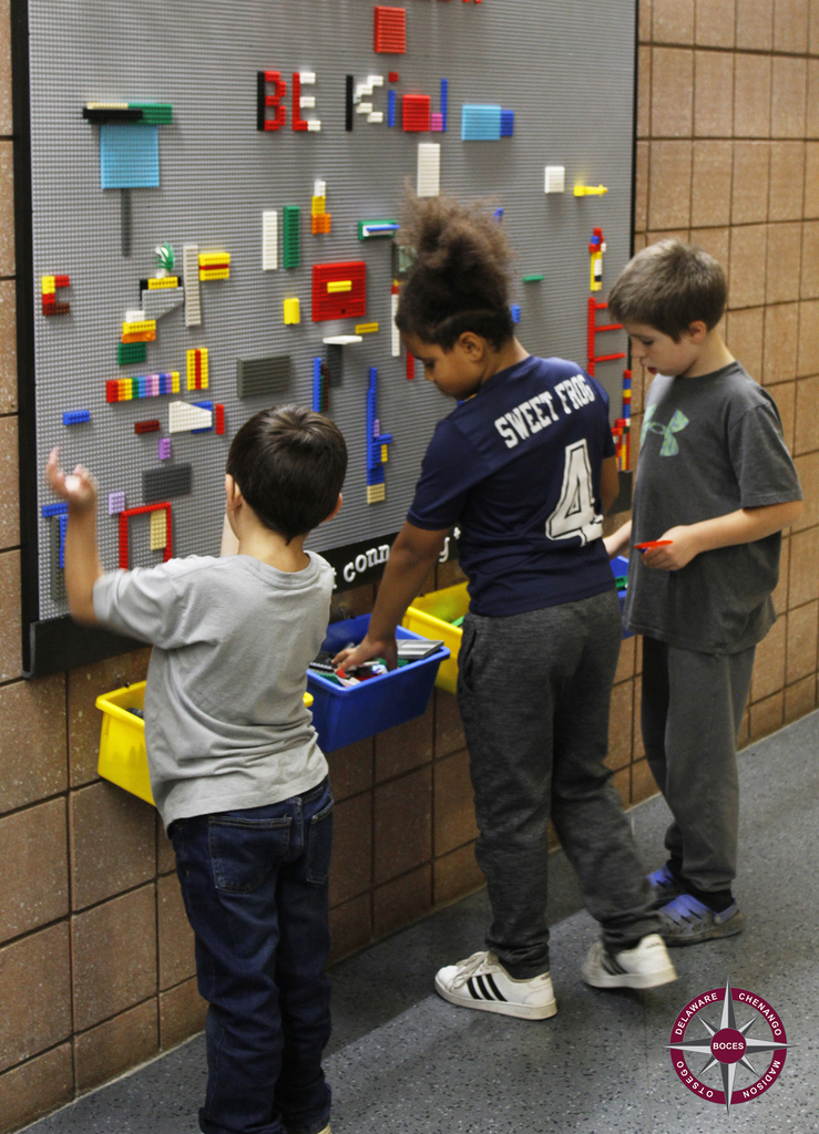 students playing at Lego wall