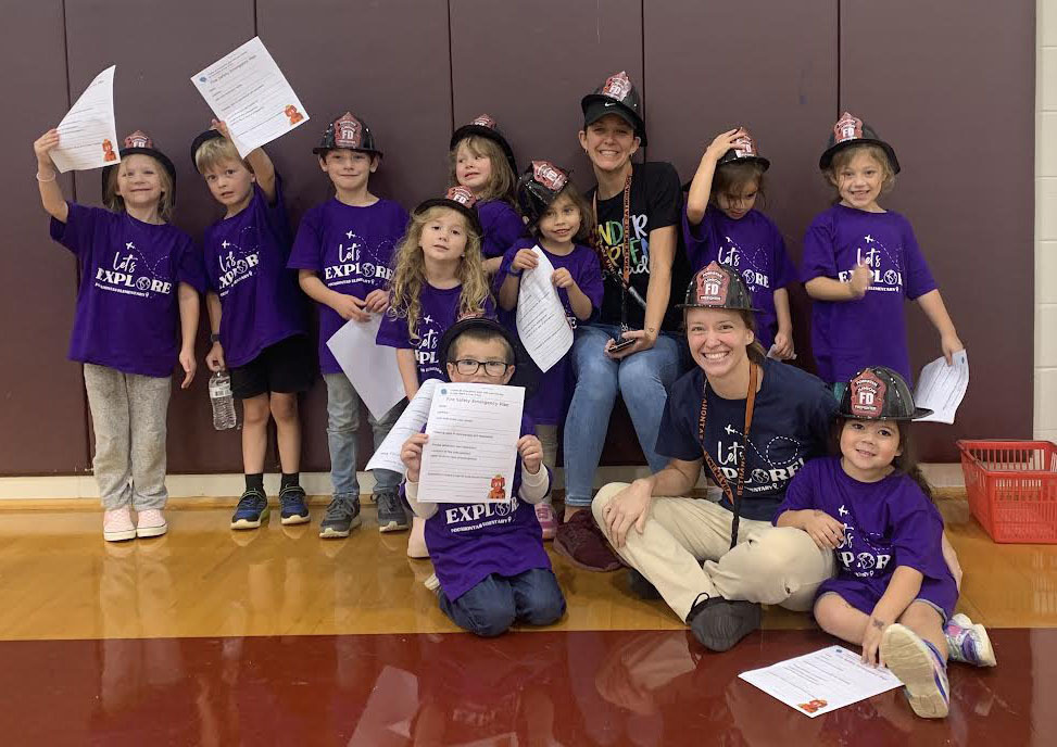 A group of children and adults smile at the camera.