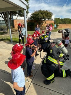students talking to a fireman
