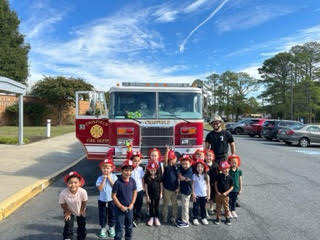 class standing in front of a fire truck