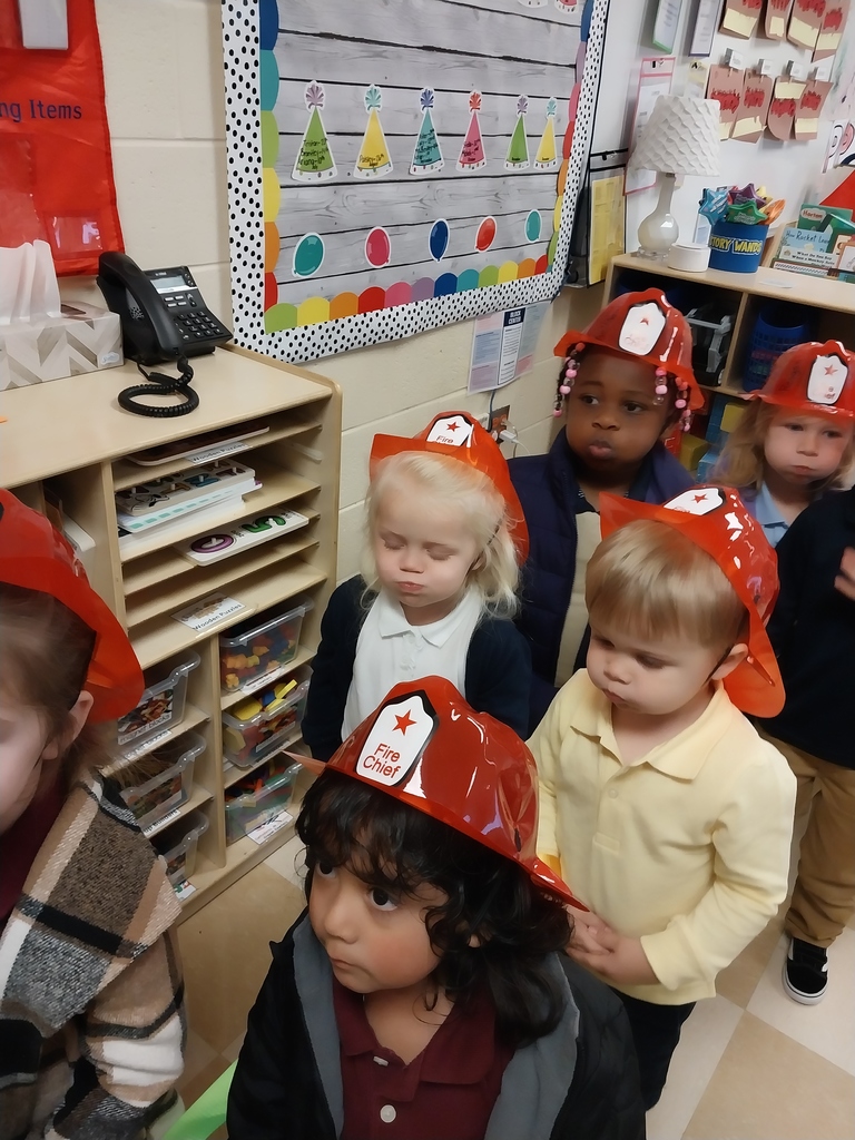 student in line waiting for fire truck wear fire hat
