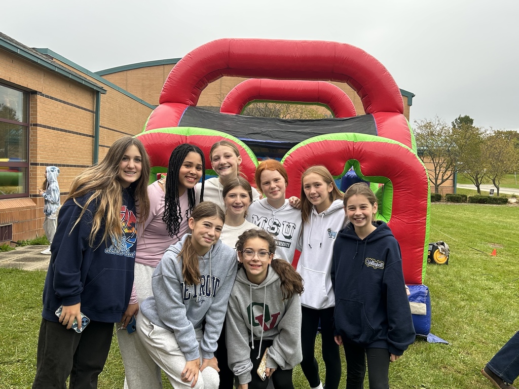 students stand by inflatable obstacle course