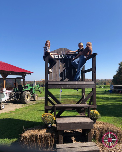 students pose on a giant chair