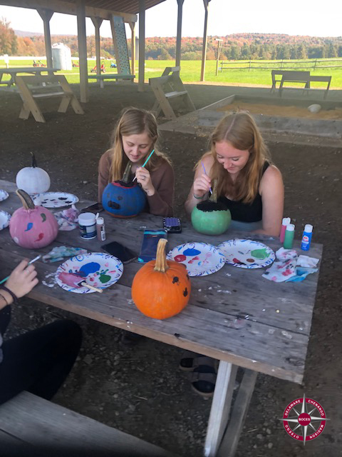 students paint pumpkins