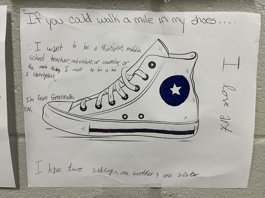 Drawing of a shoe that has been decorated and has text telling about the student who decorated it.