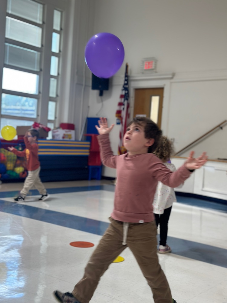 student throws and catches a balloon