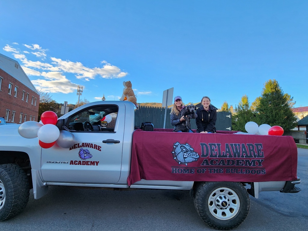 Two administrators and a dog in back of a truck before the parade
