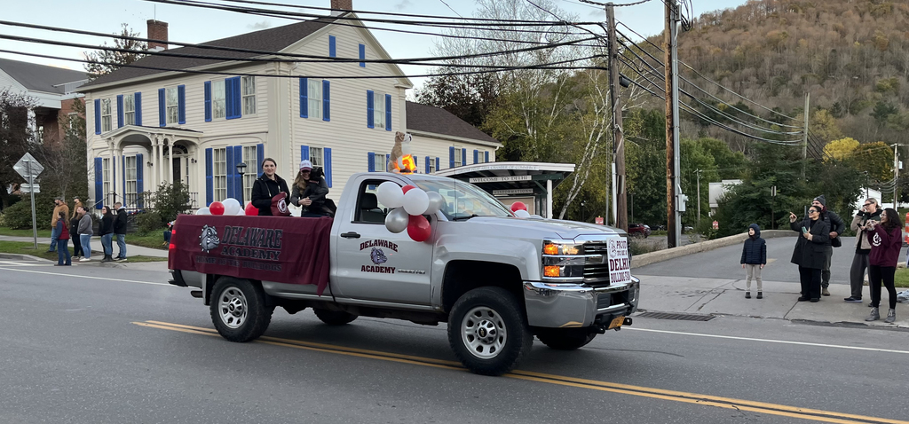 Two administrators and a dog in the back of a truck for parade