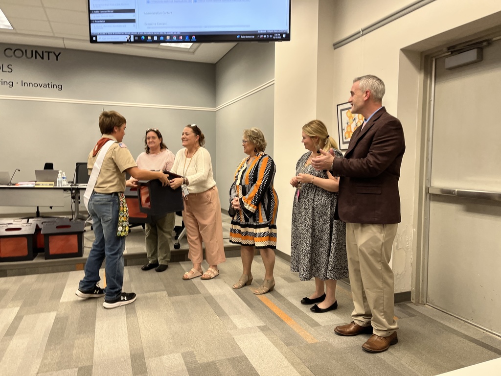 An Eagle Scout presents tab collection boxes  to school principals.