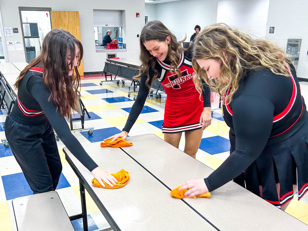 Cheerleaders wiping tables