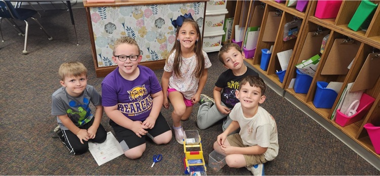 Mrs. Reyes' class using scales to measure classroom objects. 