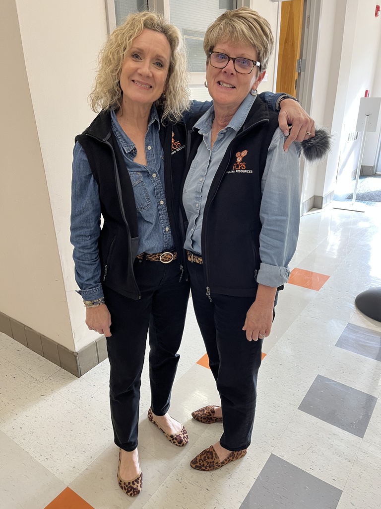 Two women pose together smiling at the camera.