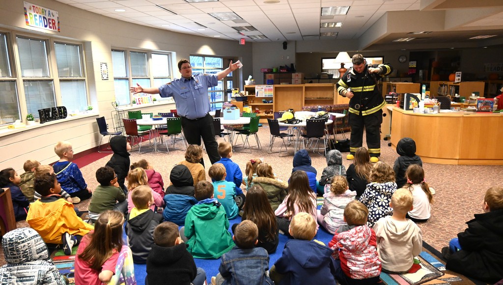 students listening to presentation from firemen