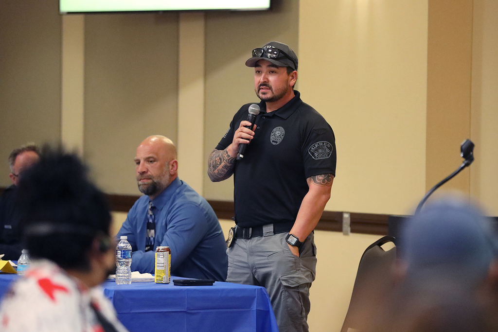 Police officer holding microphone presents to audience