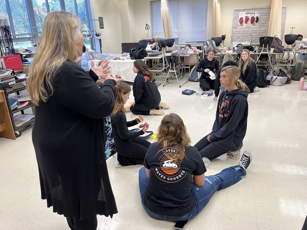 A teacher instructs students on CPR.