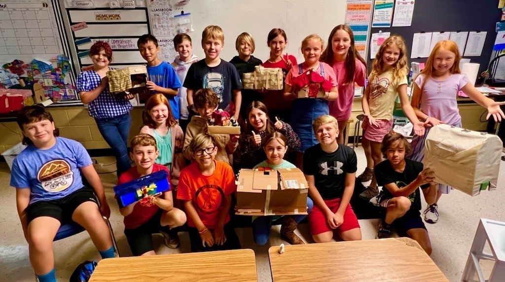 A group of fifth graders show their models of Native Virginia homes.