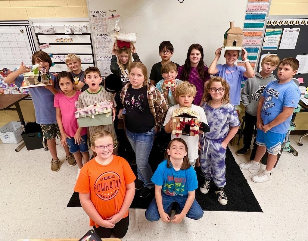 A group of fifth graders show their models of Native Virginia homes.