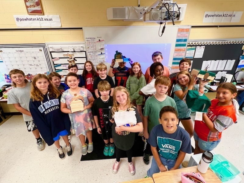 A group of fifth graders show their models of Native Virginia homes.