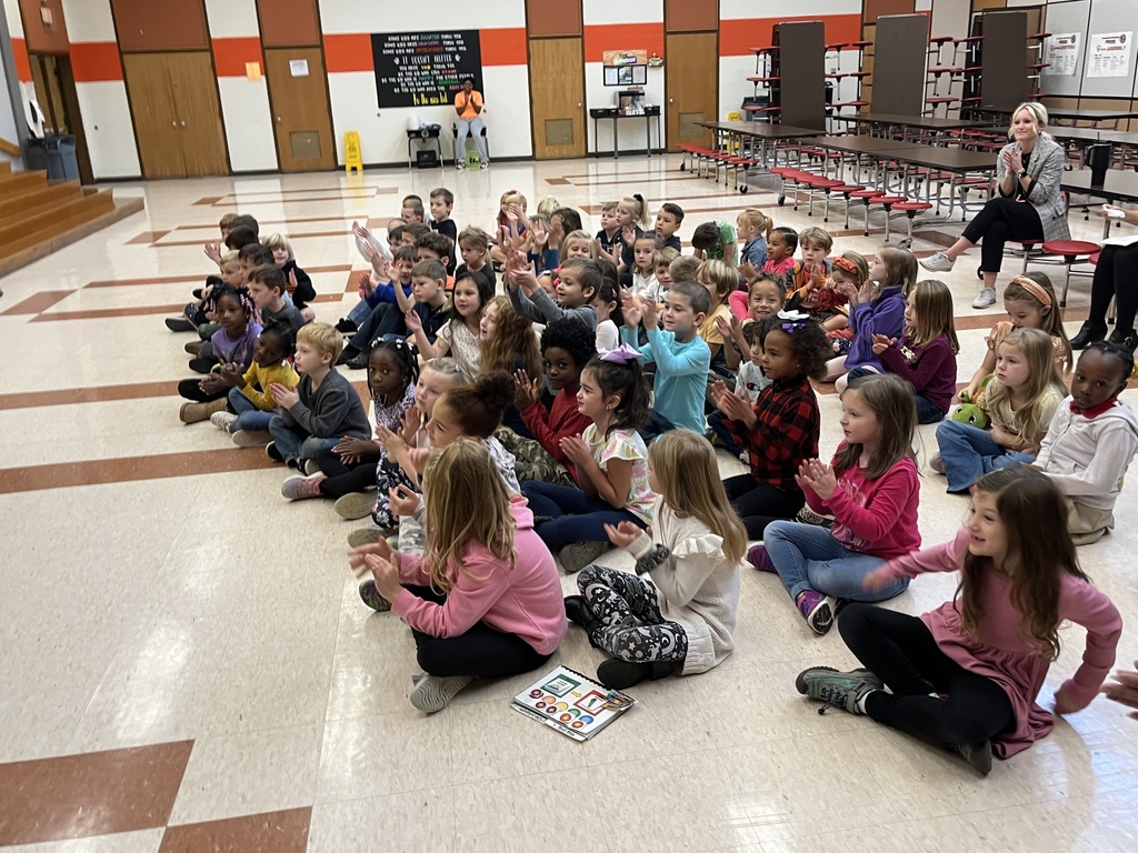 Children listen to a speaker.
