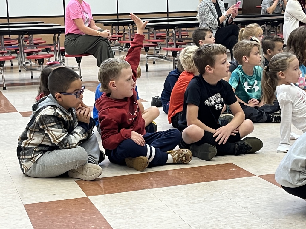 Children listen to a speaker.