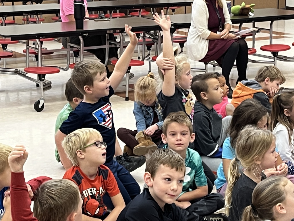 Children listen to a speaker.