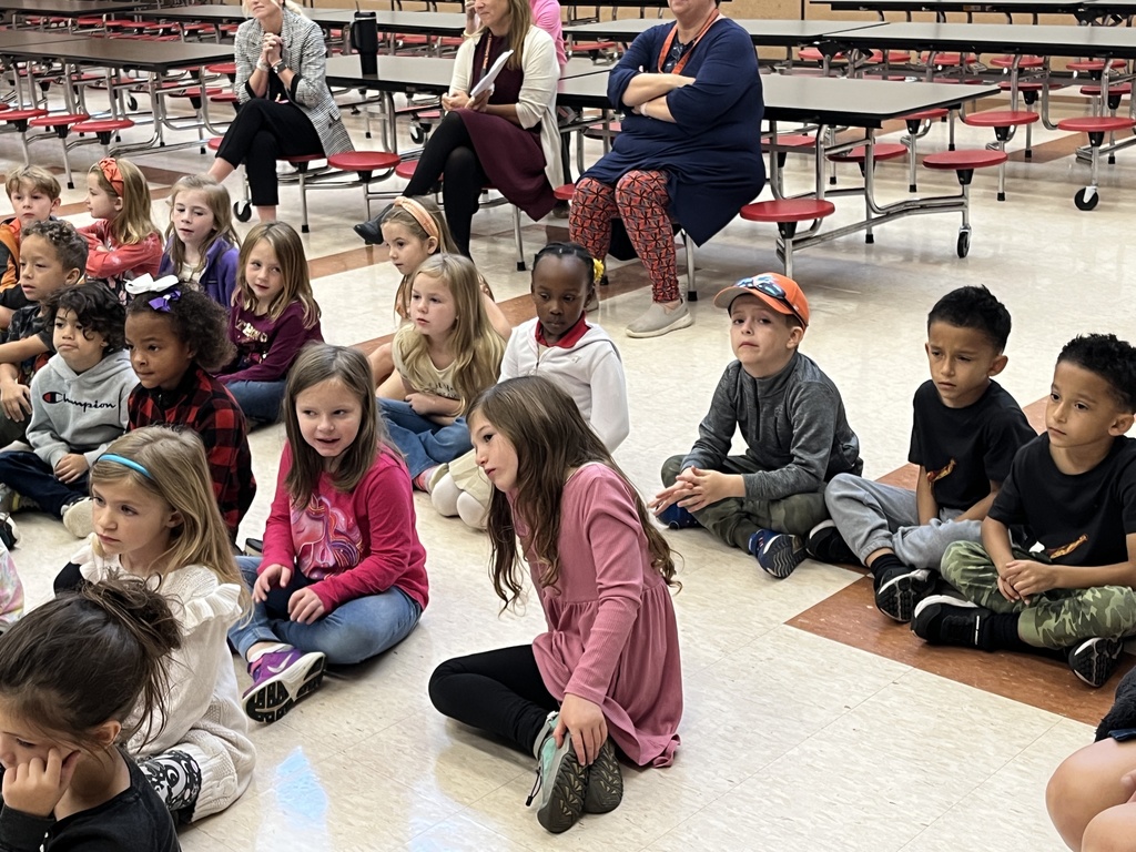 Children listen to a speaker.
