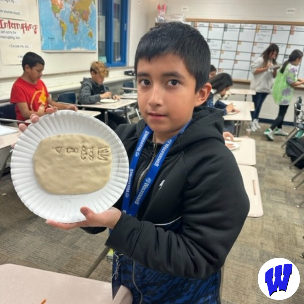 Ms. Feldkamp‘s sixth grade class wrote their name in cuneiform writing in play-dough.