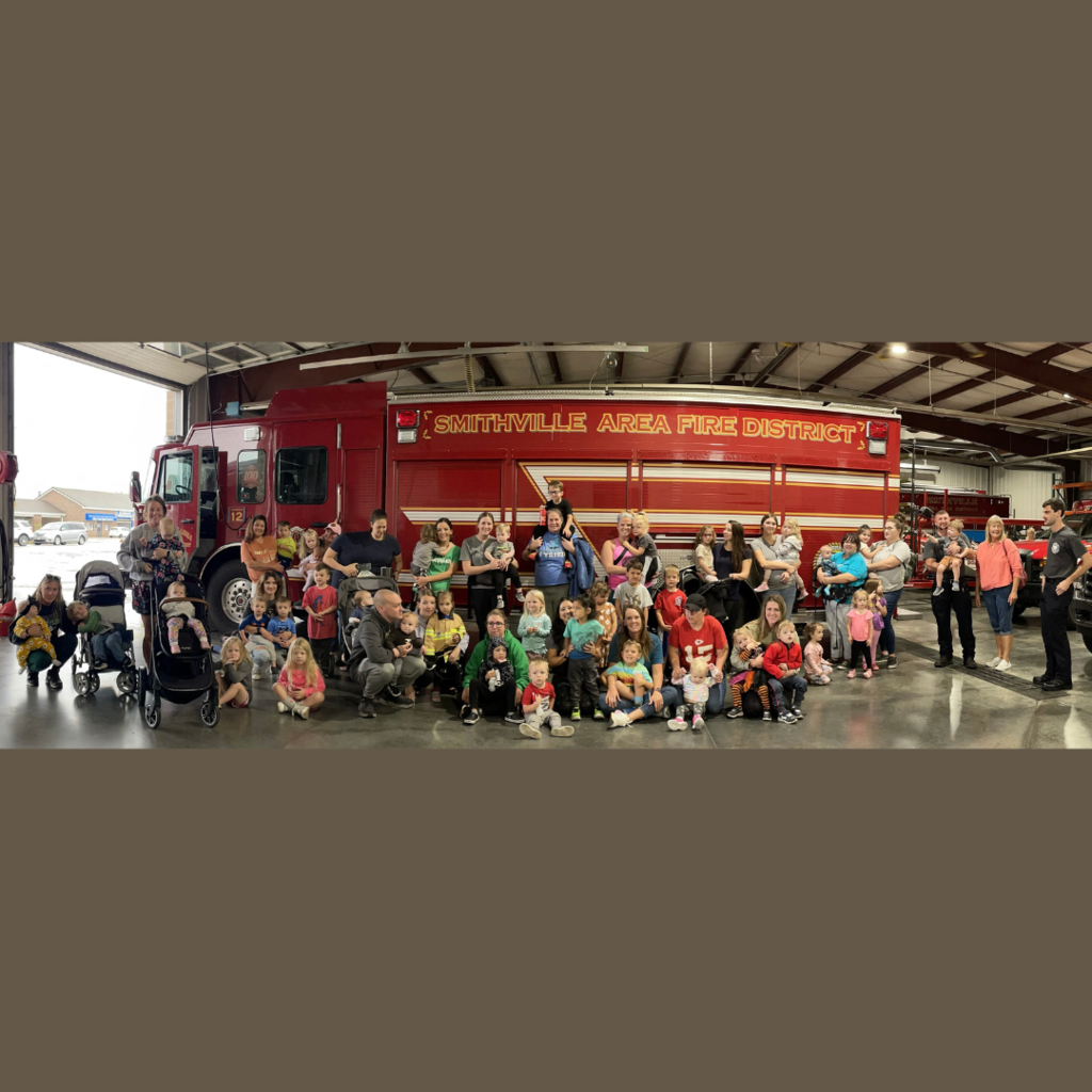 Families posesfor picture in front of fire truck