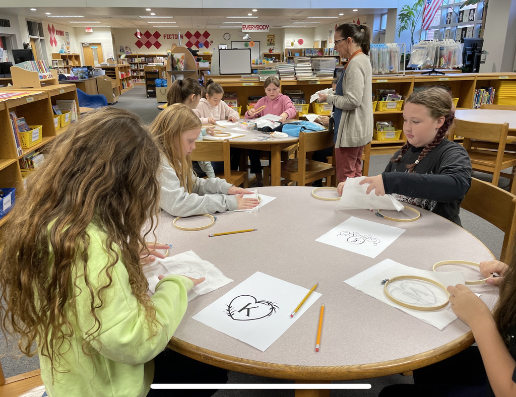 A teacher teaches students how to sew.