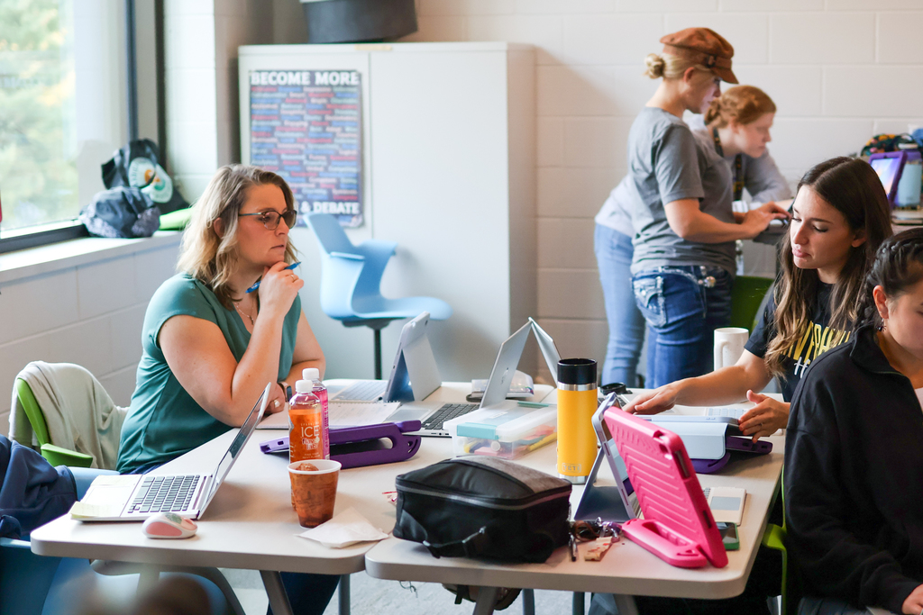 people at a desk in classroom