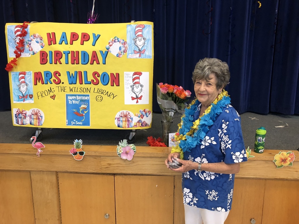 Woman standing by a happy birthday poster